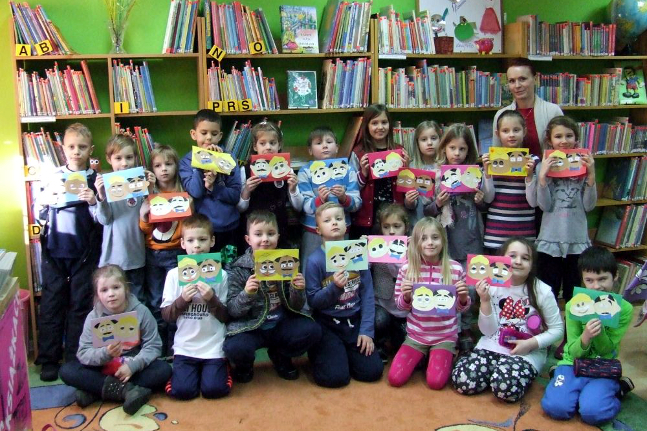 dzieci czytają książki w bibliotece
