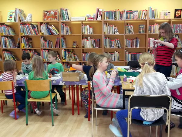 dzieci czytają książki w bibliotece