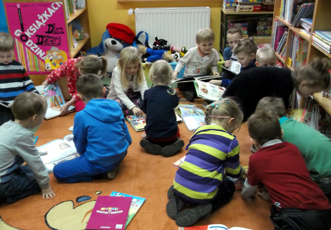 dzieci czytają książki w bibliotece