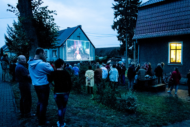 wieczorna prezentacja filmu na ścianie budynku
