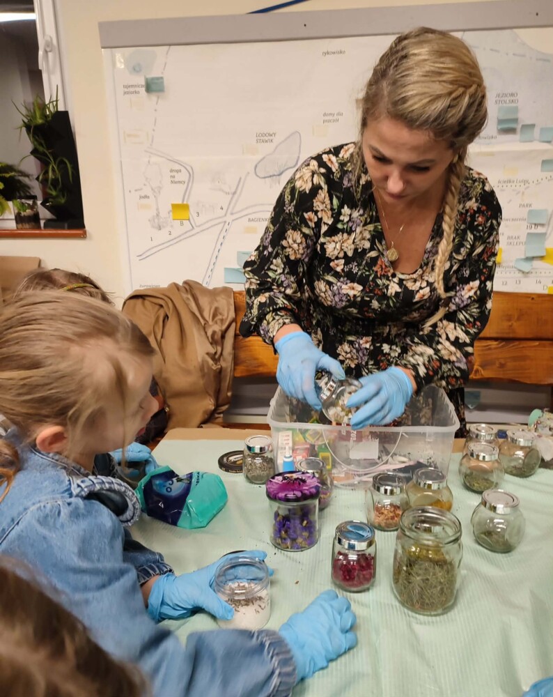 Fotografia przedstawia grupę osób przygotowujących naturalną sól do kąpieli.