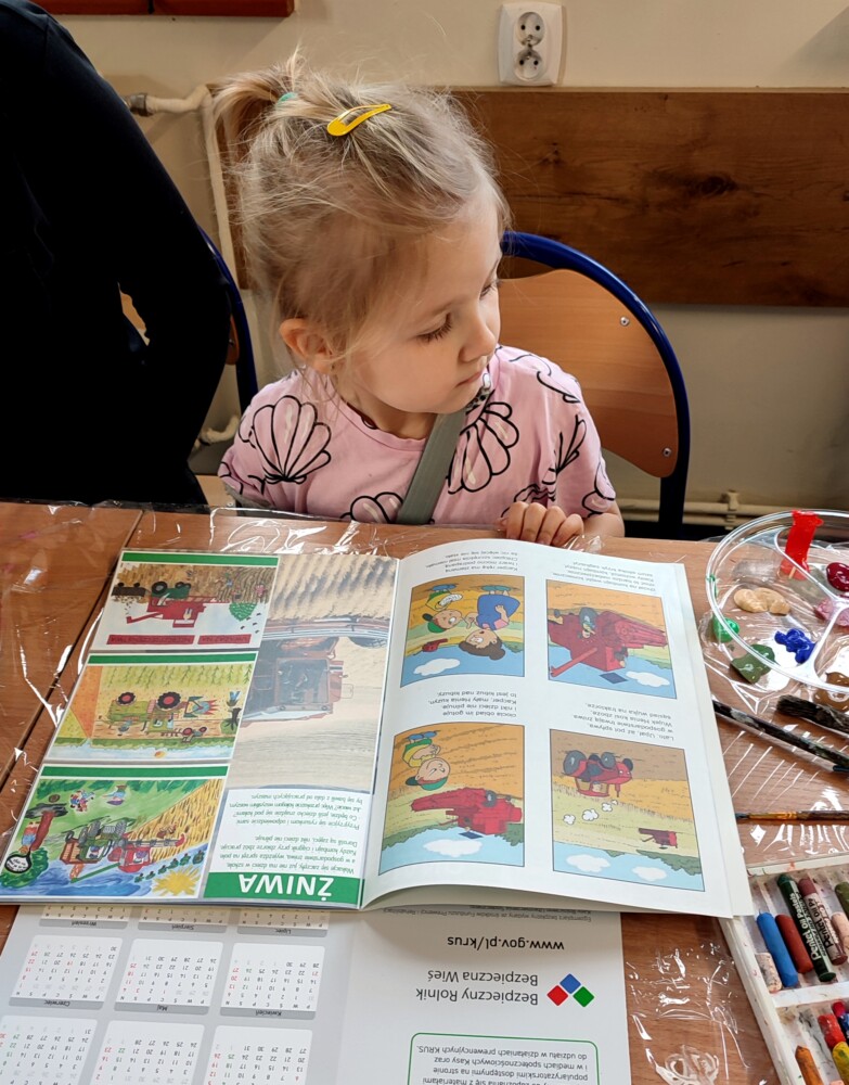 Zdjęcie przedstawiające dziewczynkę nad książką.