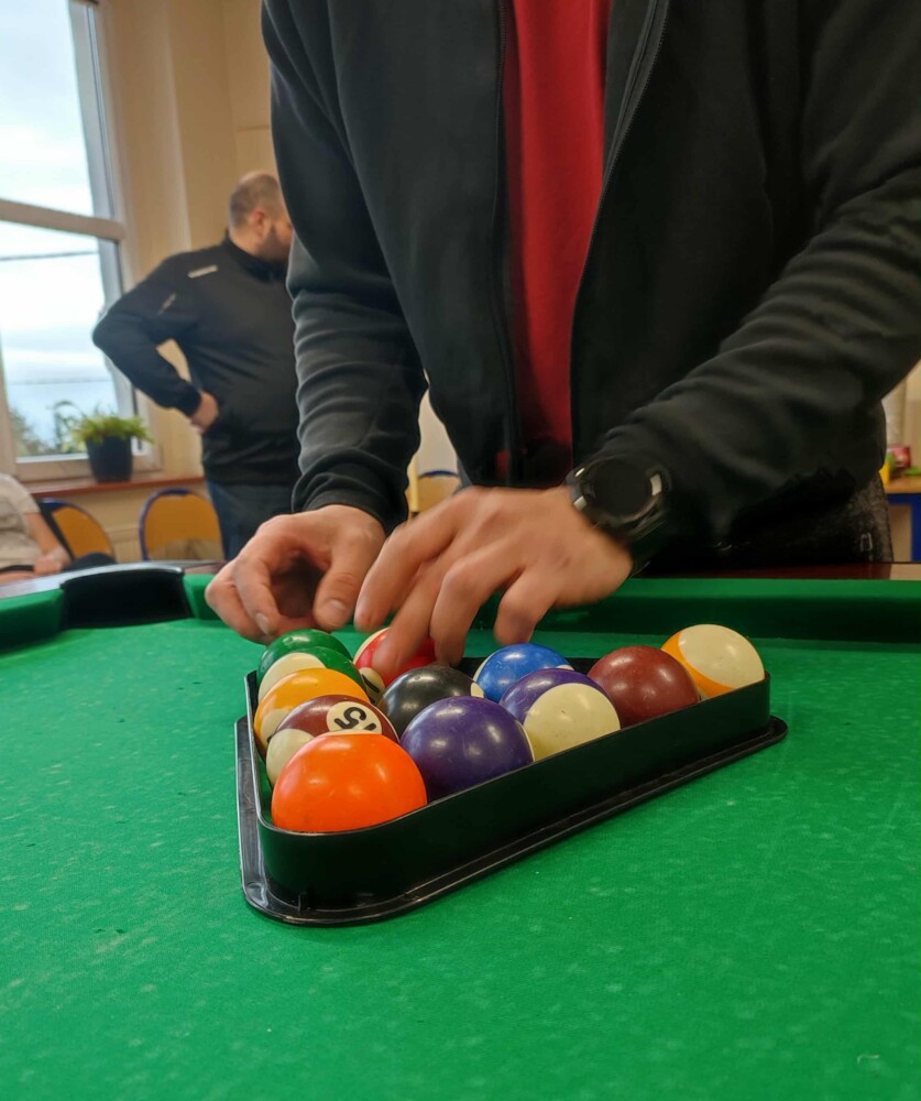 Fotografia przedstawia stół bilardowy oraz kolorowe bile do gry.
