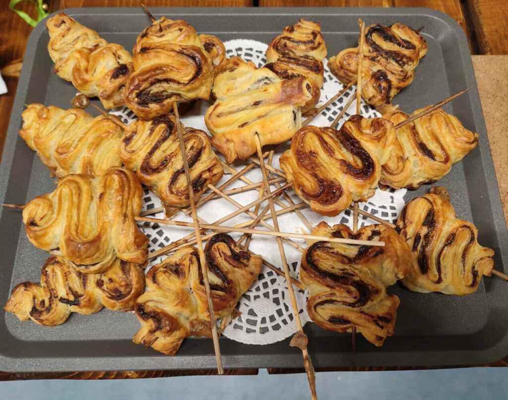 Fotografia przedstawia ciastka francuskie w kształcie choinek.